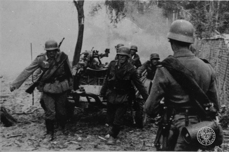  Czasy Wojenne - Żołnierze niemieccy ciągną działko wzdłuż muru podczas walk o Westerplatte.jpg