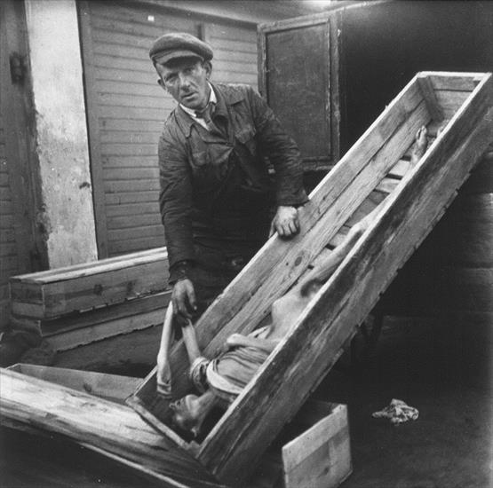 archiwalne fotogr... - An undertaker in the Warsaw ghetto cemetery on Ok... an open coffin that contains the body of woman1.jpg